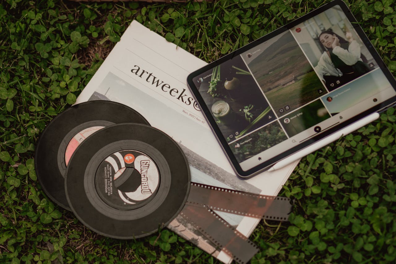 gallery-3 A flat lay of vintage films, a newspaper, and a tablet on grass.