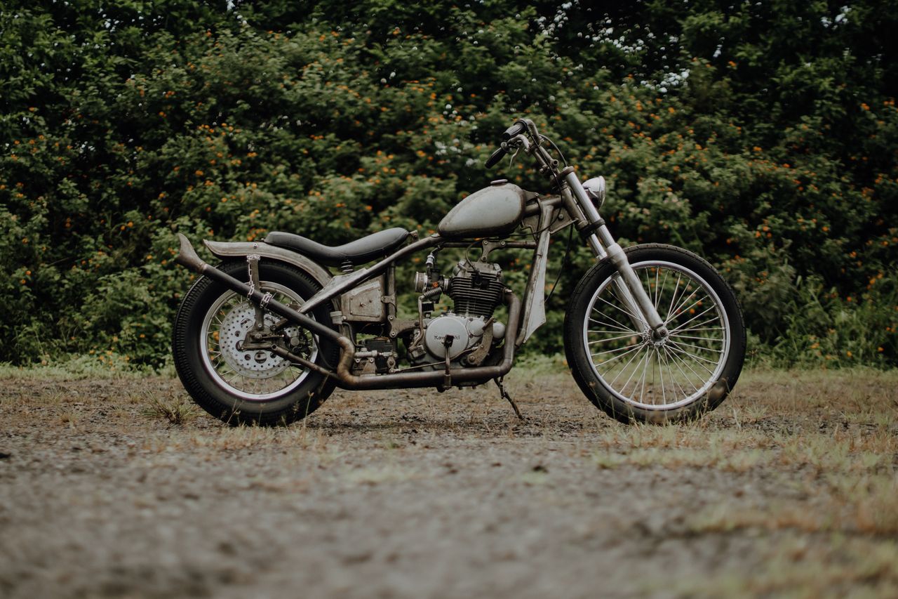 gallery-3 Rustic vintage motorcycle parked in a lush Jakarta forest.